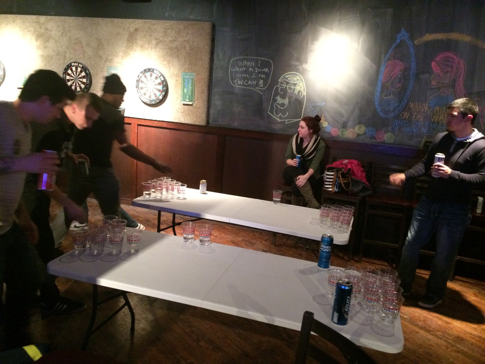 Beer pong tables with players mid-game at Tin Can Bar.