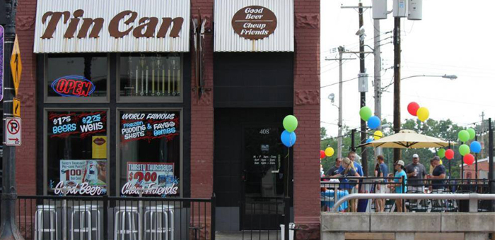 Tin Can Bar Grand Rapids exterior with open garage-door patio and blue Tin Can signage.